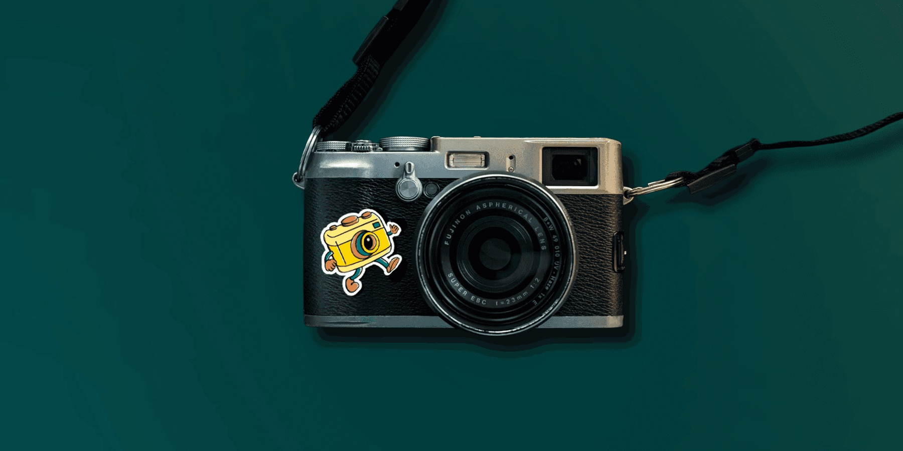 Camera character sticker applied to a vintage camera against a teal background.